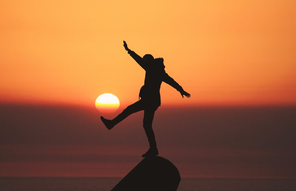 Person enjoying the sunset with a sense of joy